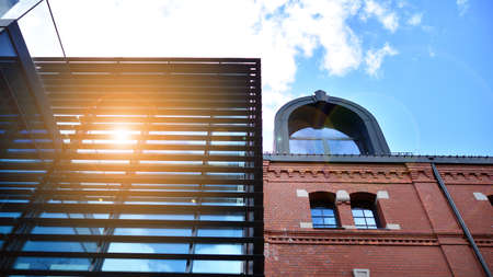 Modern office building with glass facade on a clear sky background. Abstract close up of the glass-clad facade of a modern building covered in reflective plate glass.の写真素材