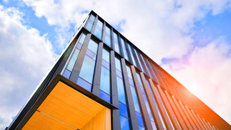 Glass buildings with cloudy blue sky background. Perspective wide angle view to steel light blue...