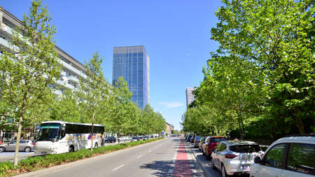 Warsaw, Poland. 16 May 2022. Glass skyscrapers against the blue sky and traffic in the city center. Colorful cityscape with buildings architecture and cars on the street. Sunny weather in the city.のeditorial素材