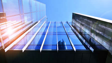 Modern office building with glass facade on a clear sky background. Transparent glass wall of office...