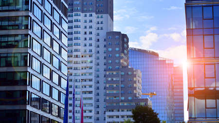 Modern glass facade against blue sky. Bottom view of a building in the business district. Low angle view of the glass facade of an office building.の写真素材