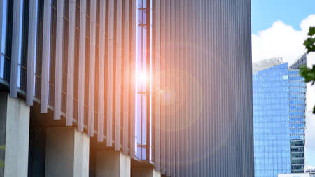 Modern glass facade against blue sky. Bottom view of a building in the business district. Low angle view of the glass facade of an office building.の写真素材