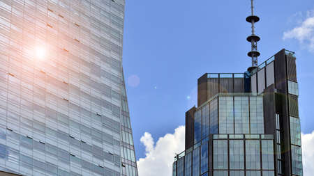 Modern glass facade against blue sky. Bottom view of a building in the business district. Low angle...
