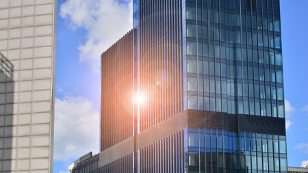 Modern glass facade against blue sky. Bottom view of a building in the business district. Low angle...