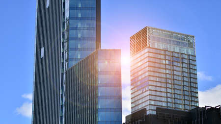 Modern glass facade against blue sky. Bottom view of a building in the business district. Low angle view of the glass facade of an office building.の写真素材