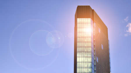 Modern glass facade against blue sky. Bottom view of a building in the business district. Low angle view of the glass facade of an office building.の写真素材