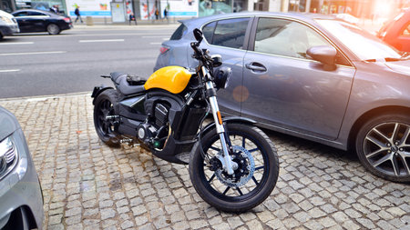 A yellow cruiser bike parked in street during sunset