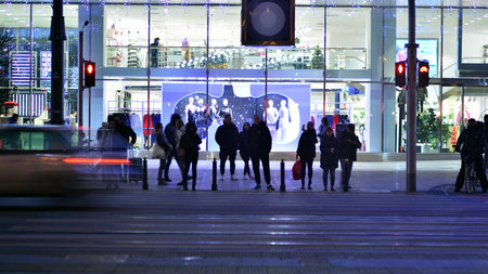 Warsaw, Poland. 23 November 2022. Evening city life in the center of Warsaw. People walking Warsaw streets at night Selective blur on people and cars in the city center at night.のeditorial素材