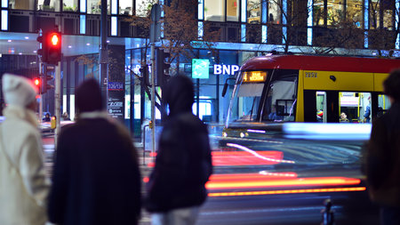 Warsaw, Poland. 23 November 2022. Evening city life in the center of Warsaw. People walking Warsaw streets at night Selective blur on people and cars in the city center at night.のeditorial素材
