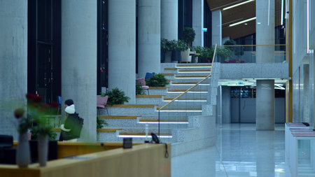 Warsaw, Poland. 23 November 2022. Evening city life in the center of Warsaw. Large windows of the lobby of an Skyliner office building and empty corridor in the modern office buildのeditorial素材