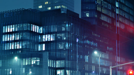 Pattern of office buildings windows illuminated at night. Glass architecture ,corporate building at night - business concept. Blue graphic filter.の写真素材