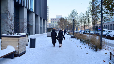 Warsaw, Poland. 14 December 2022. Winter street of a big city and people dressed warmly walk on the pavement.のeditorial素材