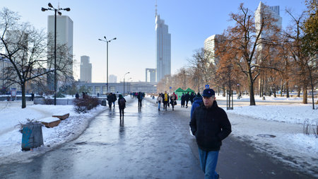Warsaw, Poland. 14 December 2022. Winter street of a big city and people dressed warmly walk on the pavement.のeditorial素材