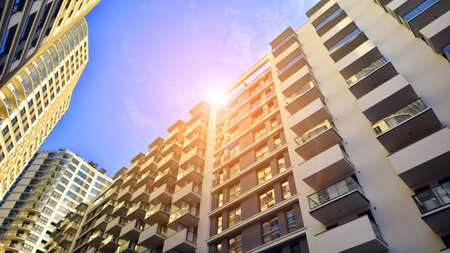 The narrow passage between modern residential buildings. Walls of high-rise apartment buildings and...