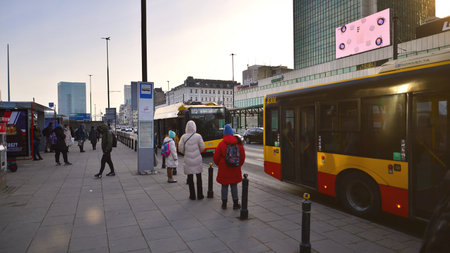 Warsaw, Poland. 10 February 2023. Winter street of a big city and people dressed warmly walk on the pavement.のeditorial素材