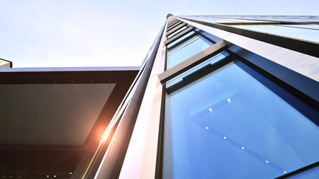 Bottom view of modern skyscrapers in business district against blue sky. Looking up at business...