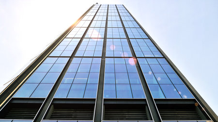 Bottom view of modern skyscrapers in business district against blue sky. Looking up at business...