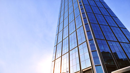 Bottom view of modern skyscrapers in business district against blue sky. Looking up at business...