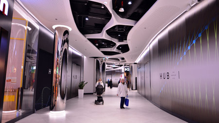 Warsaw, Poland. 8 March 2023. People walking in a shopping mall past the shops. Shopping passage The...