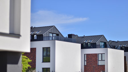 Terraced family homes in a newly developed housing estate. The real estate market in the suburbs. New single family houses in a new development area. Residential homes with modern faの写真素材