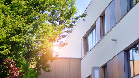 eco architecture. Green tree and new apartment building. The harmony of nature and modernity. Modern residential building with new apartments in a green residential area.の写真素材