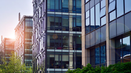 Reflection of modern commercial building on glass with sunlight. eco architecture. Green tree and...