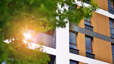 eco architecture. Green tree and new apartment building. The harmony of nature and modernity. Modern residential building with new apartments in a green residential area.の写真素材