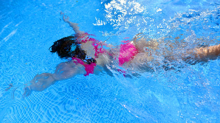 Silhouette of young woman underwater in the pool.の写真素材