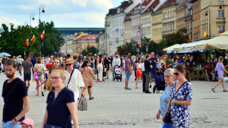 Warsaw, Poland. July 29, 2023. Crowd of people walking on a street. A crowd moving against a background of an urban old city landscape.のeditorial素材