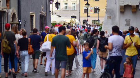 Warsaw, Poland. July 29, 2023. Crowd of people walking on a street. A crowd moving against a background of an urban old city landscape.のeditorial素材