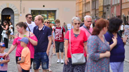 Warsaw, Poland. July 29, 2023. Crowd of people walking on a street. A crowd moving against a background of an urban old city landscape.のeditorial素材