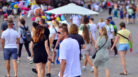 Warsaw, Poland. July 29, 2023. Crowd of people walking on a street. A crowd moving against a background of an urban old city landscape.のeditorial素材
