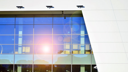 Minimalist photo of an exterior of a modern tin building with big glass showcases.
