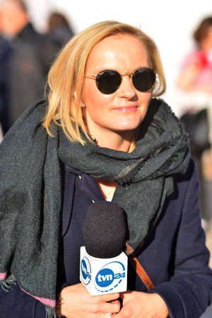 Warsaw, Poland. 24 October 2023. Reporter Maja Wojcikowska holding microphone with logo sign of TVN24 TV network company. Polish news channel. TVN 24 television station, informatioのeditorial素材