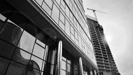 View of a skyscraper under construction. Modern architecture background. Building a high-rise building, the concept of real estate construction. Black and white.の写真素材