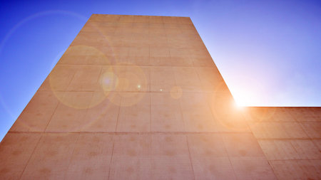 Sunlight and shadow on surface of white Concrete Building wall against blue sky background, Geometric Exterior Architecture in Minimal Street photography styleの写真素材