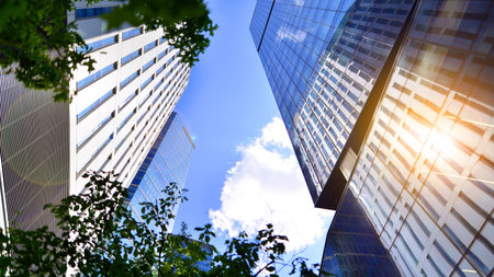 Sustainable glass office building with trees for reducing carbon dioxide. Eco-friendly building in...