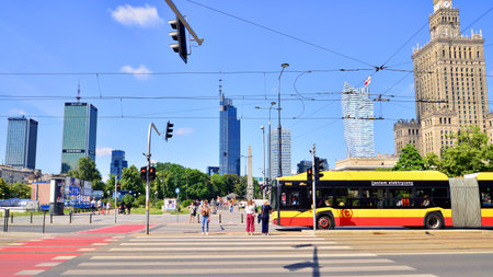 Warsaw, Poland. June 8, 2024. Street of a big city. People of different ages crossing the road through. View of a city street with residents, tourists and modern buildings. Downtownのeditorial素材