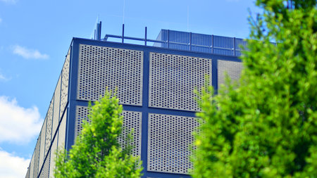 Exterior of a modern industrial building with green environment. Corporate building reduce CO2. Eco...