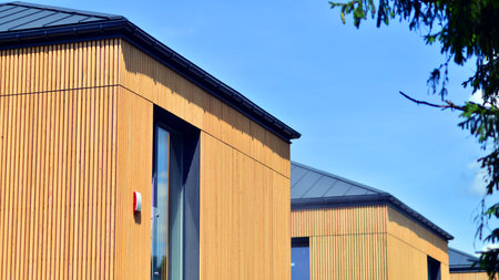 Residential homes with modern wood facade. Terraced family homes in newly developed housing estate....