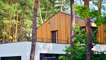 Upscale house in wooded area. Fragment of a single-family house facade.の写真素材