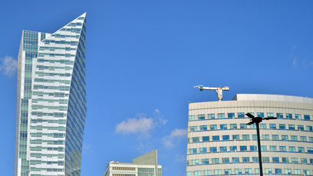 Glass building with transparent facade of the building and blue sky. Structural glass wall reflecting blue sky. Abstract modern architecture fragment. Contemporary architectural baの写真素材