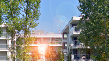 A apartment building with a lot of balconies and windows. The building is surrounded by trees and...