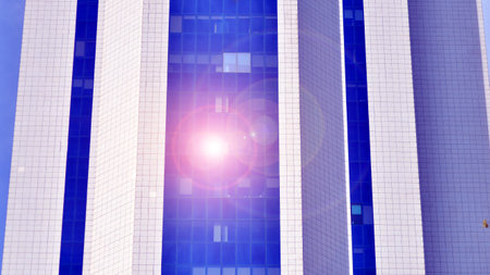 Glass building with transparent facade of the building and blue sky. Structural glass wall reflecting blue sky. Abstract modern architecture fragment. Contemporary architectural baの写真素材