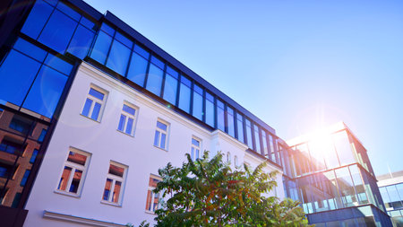 A renovation residential building and an adjacent modern office building. Modern urban development.