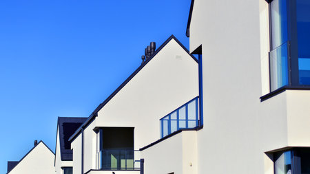 New elegant modern single family house. Terraced family homes in newly developed housing estate. Facade of a modern house with white walls. Real estate concept, european style.の写真素材