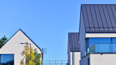 New elegant modern single family house. Terraced family homes in newly developed housing estate. Facade of a modern house with white walls. Real estate concept, european style.の写真素材