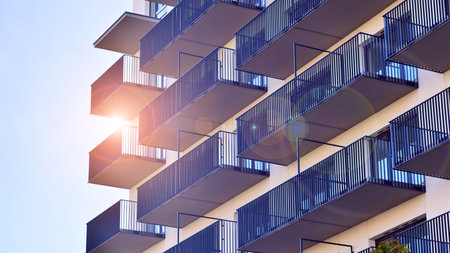 Modern high-rise apartment building in white, stand tall against a blue sky, exemplifying innovative...
