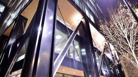 A modern architectural design intricately with details. Night lights casting reflections, capturing the essence of contemporary art and advanced engineering.の写真素材