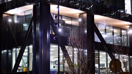 A modern architectural design intricately with details. Night lights casting reflections, capturing the essence of contemporary art and advanced engineering.の写真素材